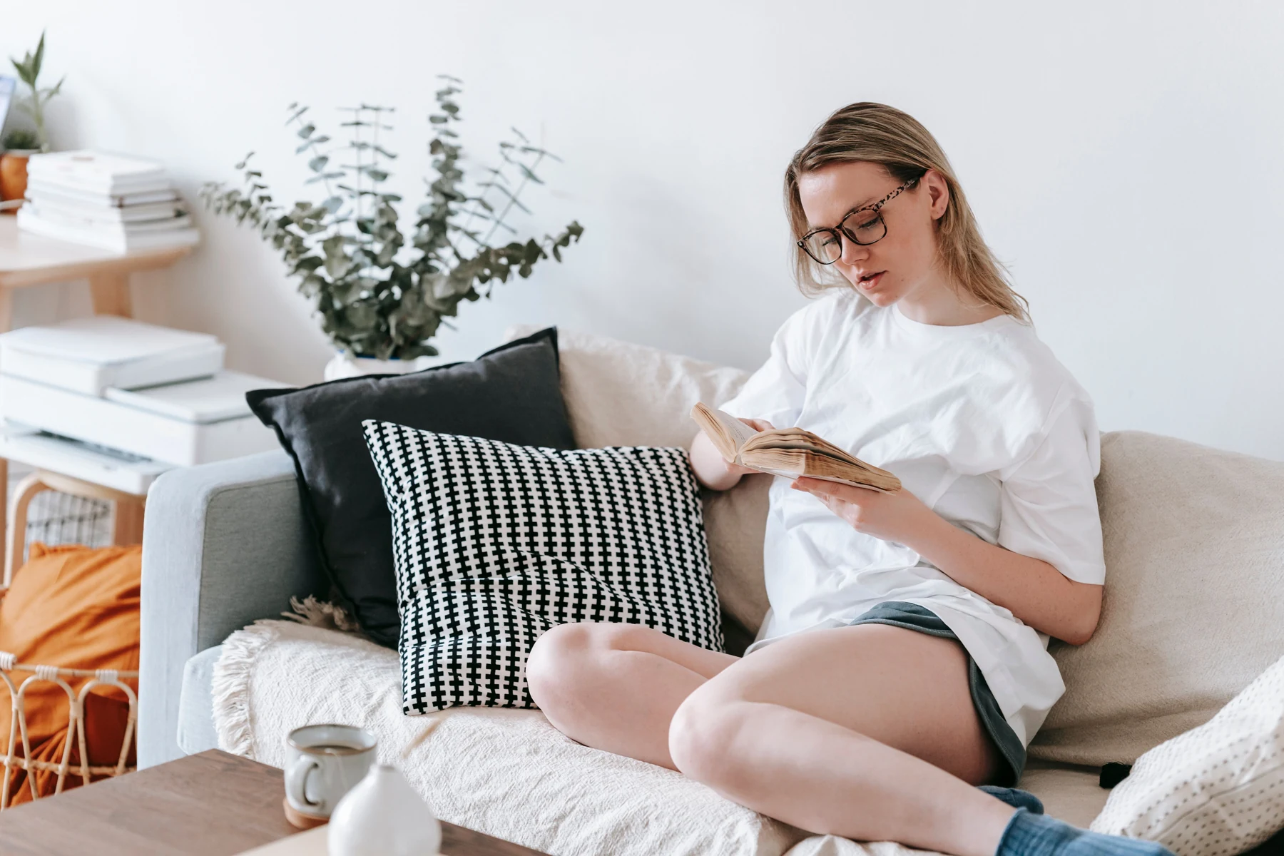 Woman sitting on a sofa with an open book